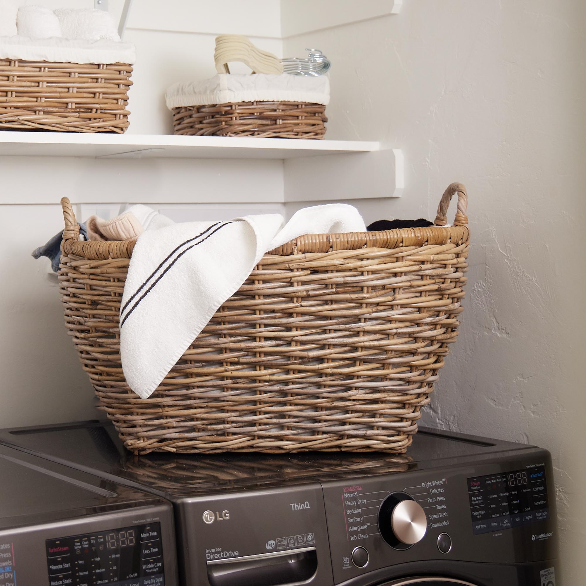 Oval Kubu Wicker Laundry Basket in Serene Grey on top of washing machine in laundry room | The Basket Lady