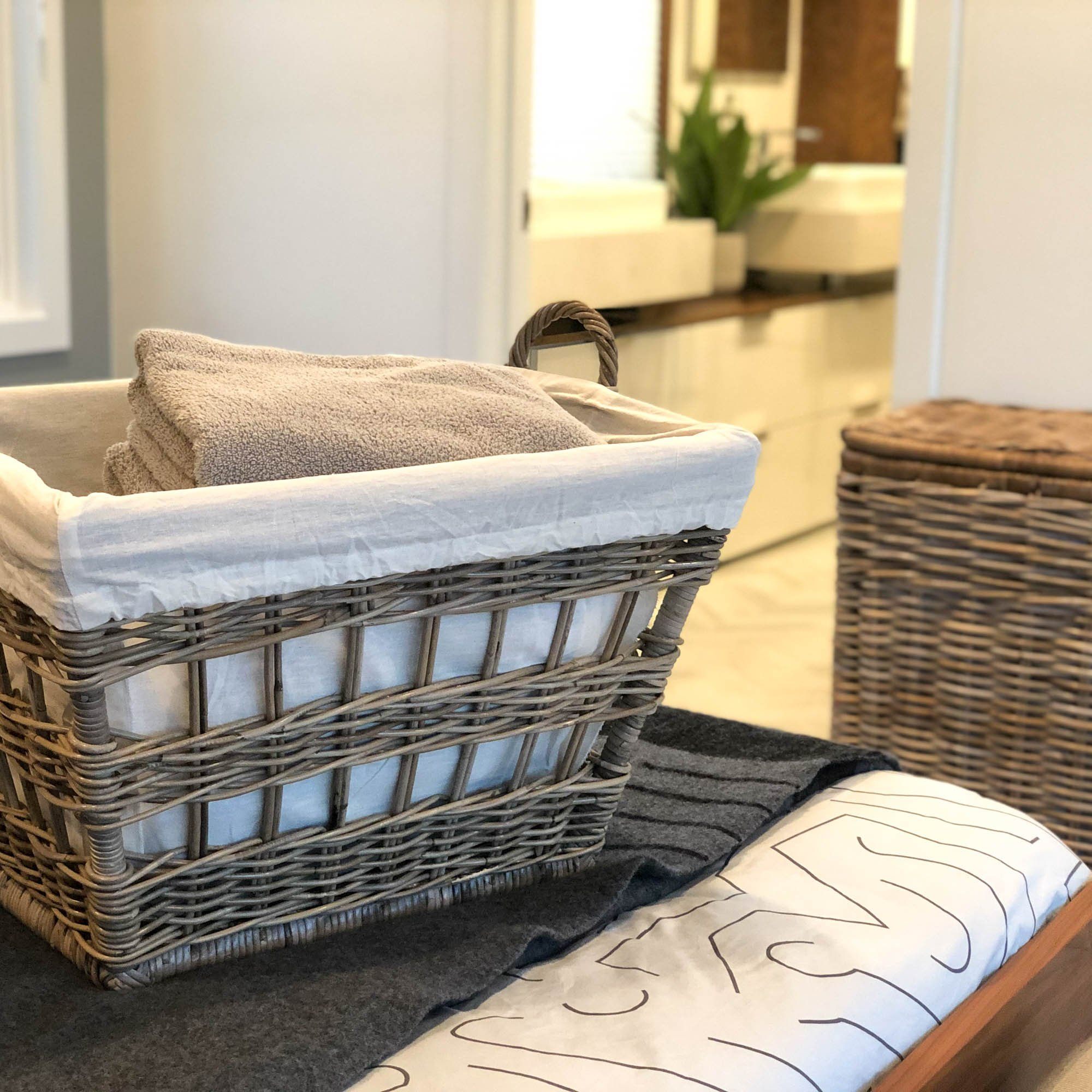 Kubu French Wicker Laundry Basket on Bed | The Basket Lady