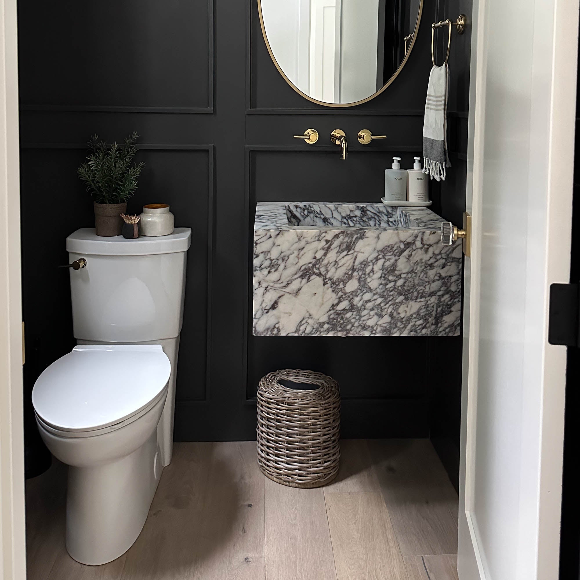 Drop-in Oval Kubu Wicker Waste Basket in Serene Grey, styled by @thesabrinatan in dark grey powder room